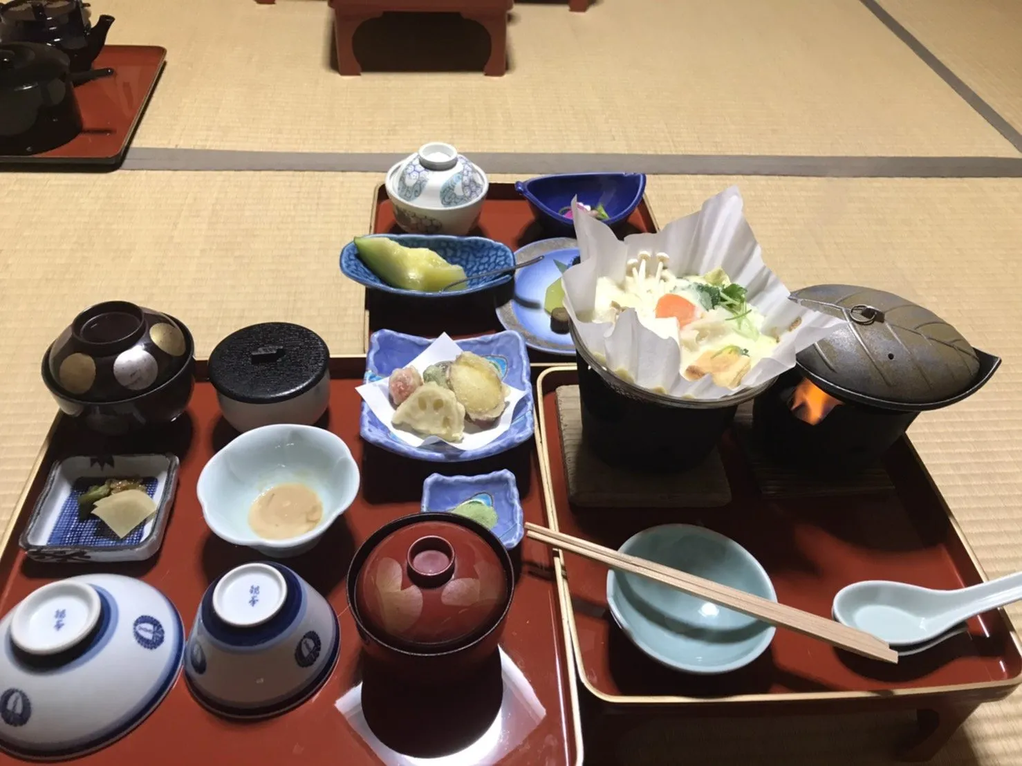 Shojin ryori dinner at Fukuchi-in: paper hotpot over a flame, vegetable tempura, and small dishes on red lacquered trays